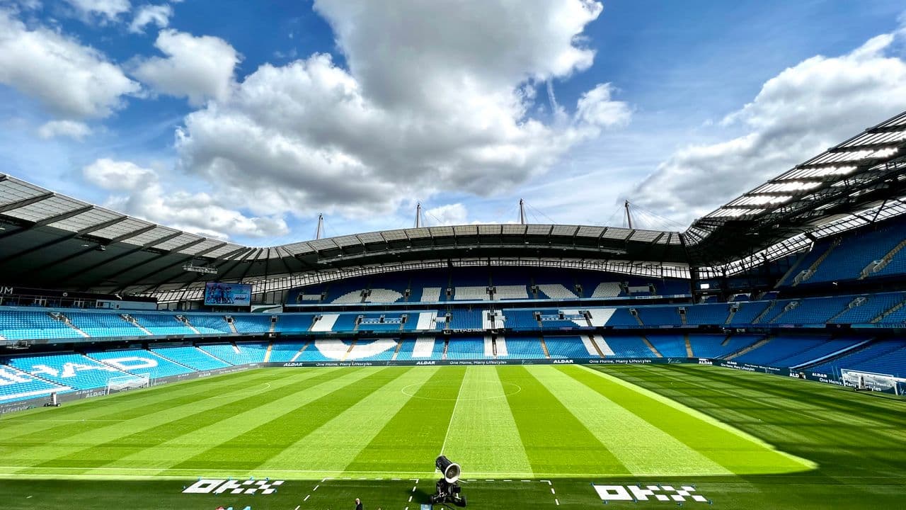 Vue intérieure d’une grande enceinte sportive, tribunes remplies.